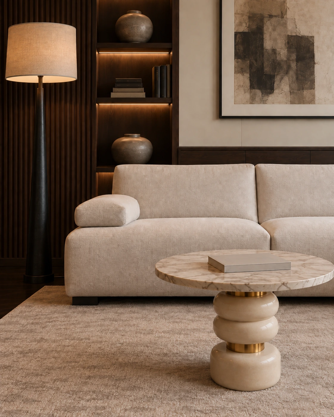 Ivory sofa, sculptural marble coffee table and floor lamp against dark walnut shelving